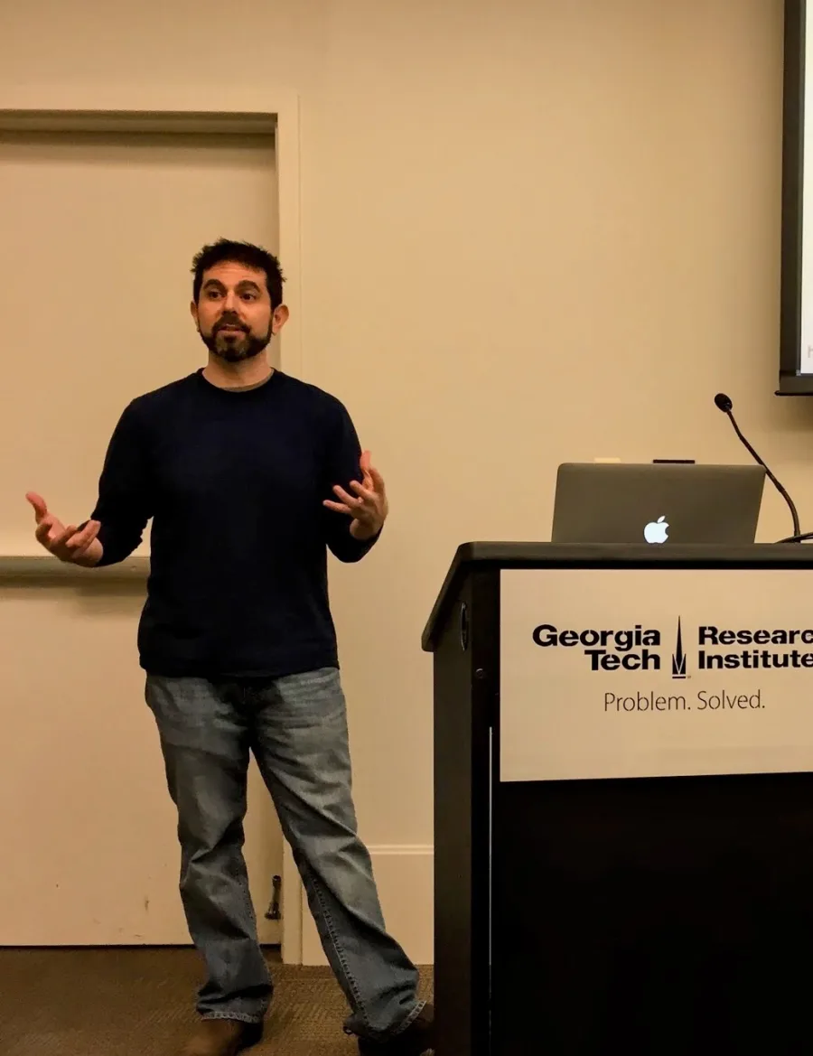 Matt Wallens speaking at a podium during an IxDA Atlanta event